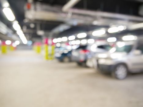 Parking garage underground with cars, industrial interior. Neon light in bright industrial building.