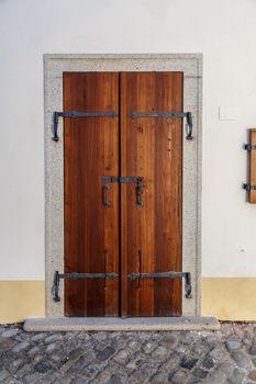 Close up detailed view of old wooden door on a white wall.