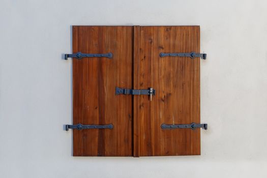Close up detailed view of old wooden door on a white wall.