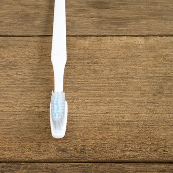 The clean white toothbrush on old wooden planks for brushing the teeth.