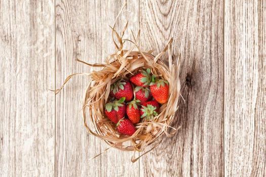 strawberries in a basket -  light wooden background