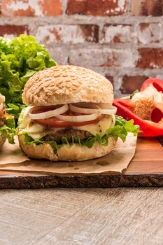 Homemade vegetarian burgers with fresh organic vegetables on rustic wooden background