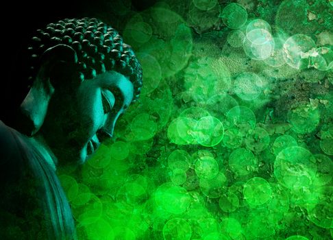 Bronze Zen Buddha Statue Meditating with Blurred Textured Green Background