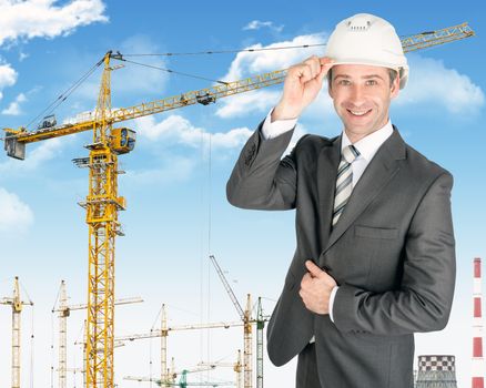 Smiling businessman in helmet on building site