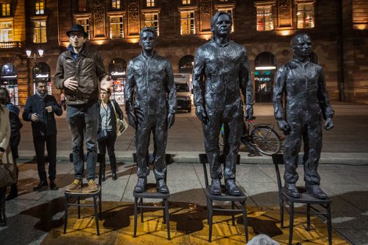 FRANCE, Strasbourg: Antoine Deltour stands on live size bronze sculpture Anything to say? of Italian artist Davide Dormino, portraying (2nd L-R) former National Security Agency (NSA) contractor and whistleblower Edward Snowden, WikiLeaks founder Julian Assange and former US soldier Chelsea Manning convicted of violations of the Espionage Act, in Strasbourg on November 17, 2015. The sculpture aims to be an interactive public art project for the freedom of speech. He and another former employees of accountancy giant PwC go on trial in Luxembourg on April 26, 2016 along with a French journalist, accused of leaking details of corporate tax deals that have fueled global demands for reform.