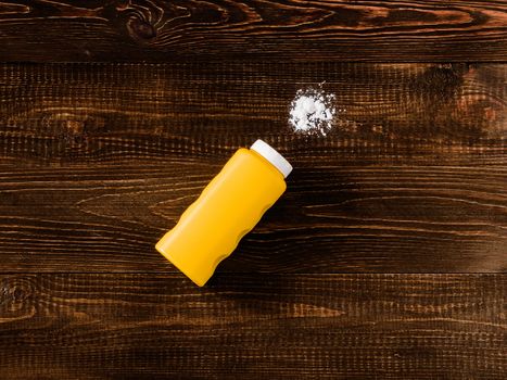 Spilled baby talcum powder on dark wooden background. Flat lay