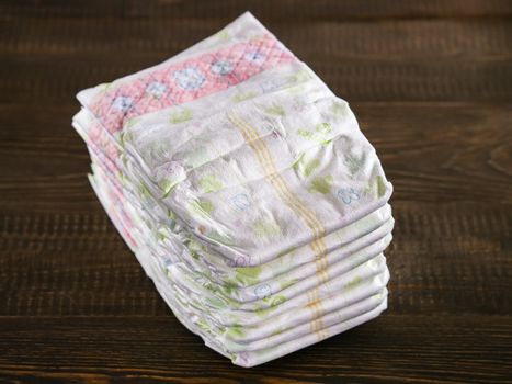 Stack of disposable diapers on a wooded background