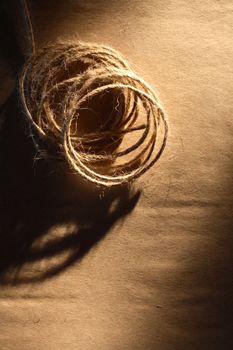 Skein of twine on old brown paper with shadow