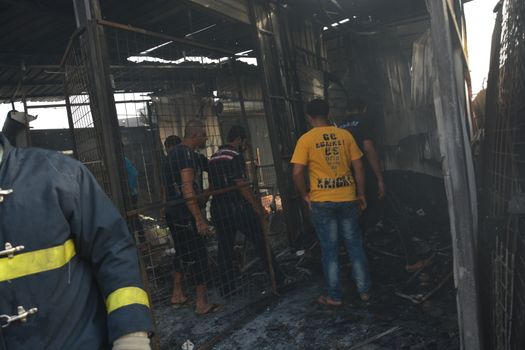 IRAQ, Baghdad: People gather in a predominantly Shi'ite Muslim district of eastern Baghdad as Iraqi security forces and firefighters secure the site of a suicide bombing claimed by the Islamic State group in New Baghdad area, on April 25, 2016. The blast ripped through shops, killing at least eleven people.