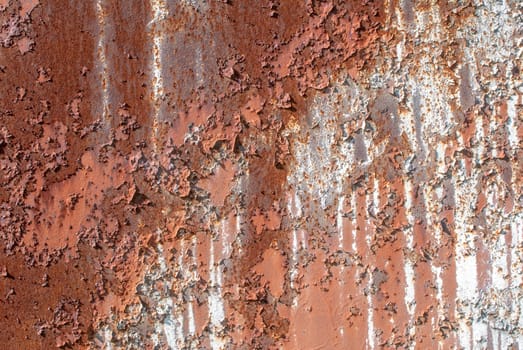 rusty iron surface covered with old chipped paint, which has long been influenced by different climatic conditions