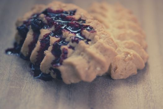 cookies with blueberry jam on wooden table