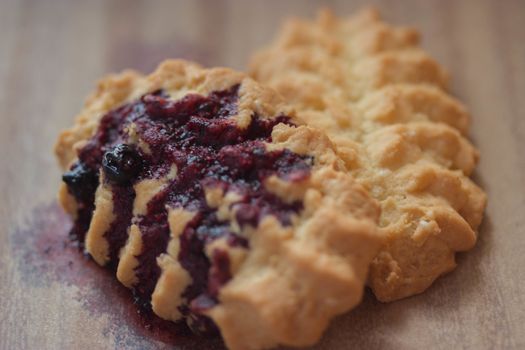 cookies with blueberry jam on wooden table