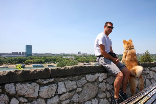 Akita Inu with its owner enjoying beautiful city view