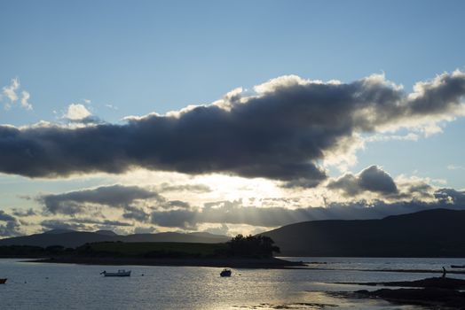 boats in a quiet bay with island near kenmare on the wild atlantic way ireland just before sunset