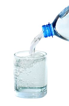 Mineral water flowing from bottle to glass. Isolated with clipping path