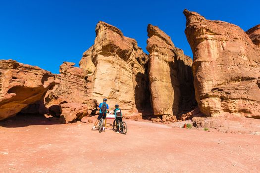 desert landscape, people riding bicycles along the canyon