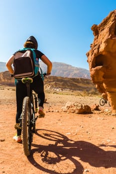 desert landscape, people riding bicycles along the canyon