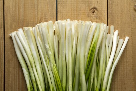 fresh green onions on a wooden Brown background