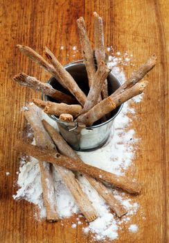 Freshly Baked Whole Wheat Bread Sticks in Tin Bucket with Dough closeup on Wooden Cutting Board