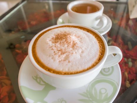 Close up white cup of Coffee, latte on the wooden glasses table