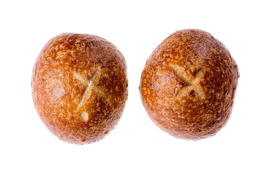 Two crusty round fresh sourdough rolls or buns decorated with crosses displayed side by side on a white background viewed from the top