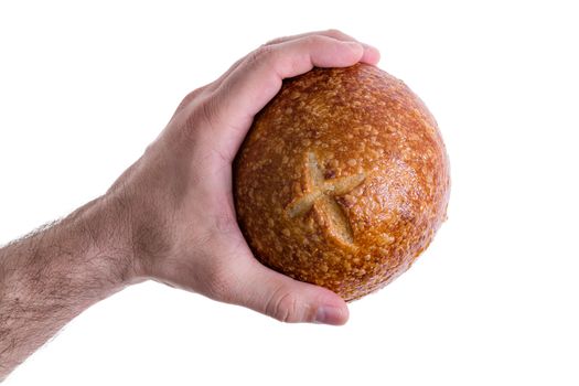 Clean male hand grasping a sourdough bun or bread roll with a crispy crust decorated with a cross isolated on white