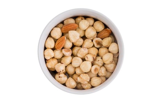 Ramekin of fresh roasted hazelnuts and almonds served ready for snacks as an appetizer to a meal, overhead view isolated on white
