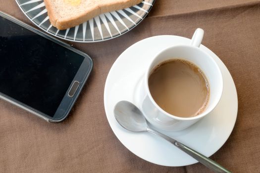 Coffee and cell phone on the table.