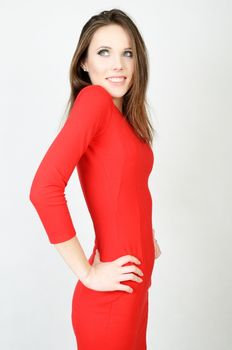 Young female model. Happy girl with smiling face, kind expression. Girl wearing red dress.  
