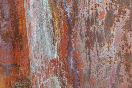 rusty iron surface covered with old chipped paint, which has long been influenced by different climatic conditions