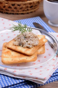 Appetizer of fish paste (forshmak) on crackers on a plate