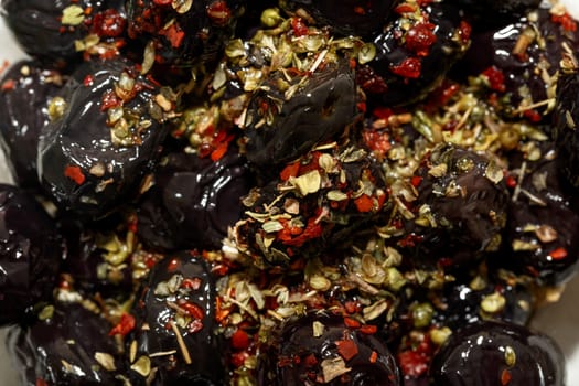 Close up detailed view of black olive with spices on.