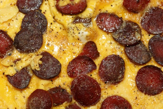 Close up detailed view of tasy omelette with sausage.