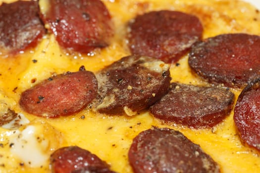 Close up detailed view of tasy omelette with sausage.