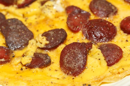 Close up detailed view of tasy omelette with sausage.