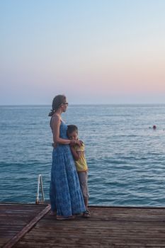 mother and son on the pier in the evening at Alania, Turkey