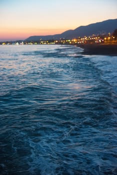 Defocused background of blue sea with waves in the evening