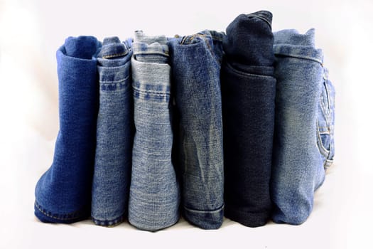 Blue jeans pants pile on a white background.