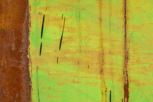 fragment of an iron surface is covered with green color paint, which has long been under the influence of different climatic conditions