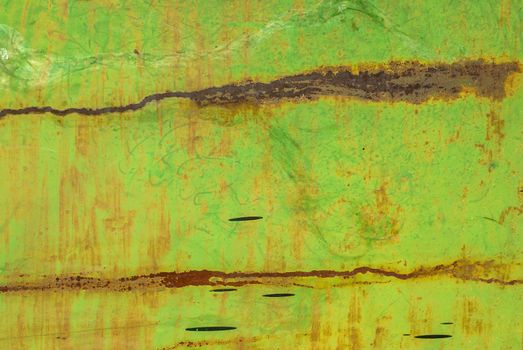 fragment of an iron surface is covered with green color paint, which has long been under the influence of different climatic conditions