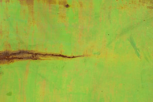 fragment of an iron surface is covered with green color paint, which has long been under the influence of different climatic conditions
