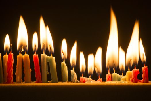 Series of small lighted candles on a black background