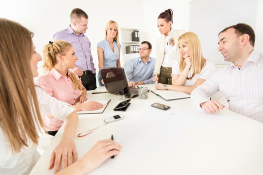 Happy Business people in the office discussing project on laptop at meeting.