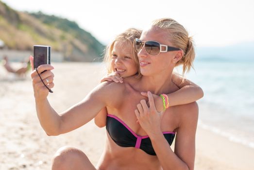 Mother and daughter selfie photographed at the beach