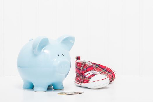 Porcelain piggy bank and baby shoes.  Portrays the concept of starting to save early in life.