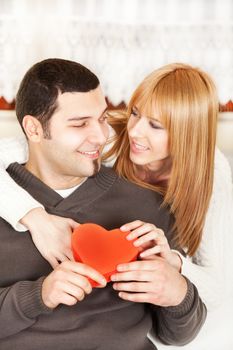Happy young couple in love with red heart