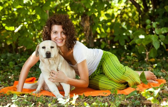 Happy young woman and dog in a forest