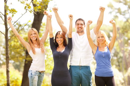 Happy friends in nature with raised arms