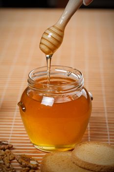 Honey with wood stick pouring