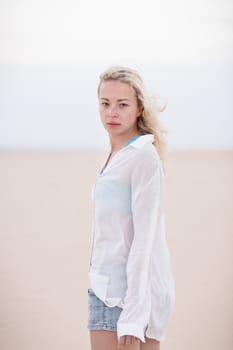 Beautiful sensual woman alone at beach. Melancholic vintage mood. Summer moved on.